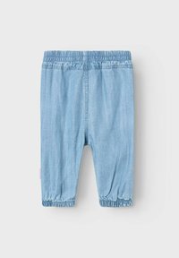 Shorts di denim blu chiaro con vita elastica e polsini arricciati, caratterizzati da una superficie liscia e una vestibilità rilassata.