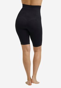 Shorts neri a vita alta, senza cuciture, con una texture liscia e elastica. Progettati per arrivare fino a metà coscia, presentano una silhouette aderente.