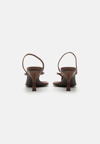 Las sandalias de tacón marrones presentan correas delgadas y una silueta elegante y contorneada. Los tacones tienen una base ligeramente más ancha para mayor estabilidad.