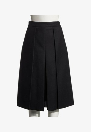 Jupe plissée noire longueur genou sur un mannequin blanc avec une ceinture ajustée et un pli central devant.