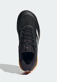 Černá sportovní obuv s texturovaným svrškem, elastickými tkaničkami a třemi bílými pruhy. Disponuje gumovou podrážkou a polstrovaným límcem.