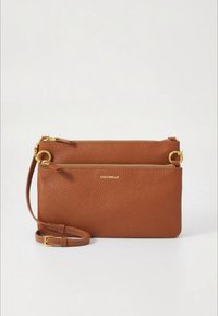 Barna bőr oldaltáska arany cipzárral, puha tapintású felülettel, állítható pánttal és dombornyomott márkajelzéssel.