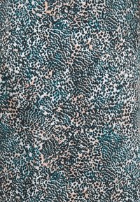 Musterstoff mit einem hellen Pfirsichhintergrund und türkisfarbenen sowie schwarzen Punkten, der ein abstraktes Tierdruckdesign erzeugt. Glatte Textur.