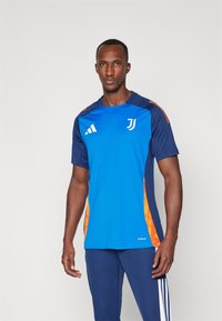 T-Shirt atlético azul e marinho com mangas curtas, apresentando detalhes em laranja e um logótipo no peito. Feito de um material leve e flexível.