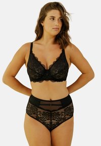 Bralette en dentelle noire avec des bords festonnés, doté d'une fermeture à l'avant. Culottes haute taille en dentelle noire avec un panneau en maille et un motif floral.