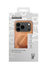 Glitter Glow-deksel for iPhone 17 Pro, har et gjennomsiktig deksel med en kobberskimrende overflate og en sirkulær MagSafe-kompatibel aksent. Resirkulerte materialer brukt.