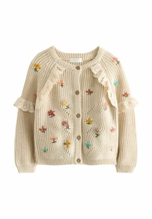 Cardigan en tricot crème avec boutons en bois, fleurs multicolores brodées et détails en dentelle crème avec volants aux épaules et aux manches.