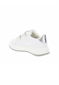 Sneaker bianco con cinturini in Velcro, suola in gomma e un accento metallico argento sul tallone. Materiale sintetico simile alla pelle e forma arrotondata.