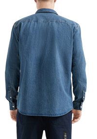 Denim shirt in medium blue met lange mouwen en een klassieke kraag. Heeft knoopsluiting bij de mouwen en een afgeronde zoom, met een gemêleerde stof.