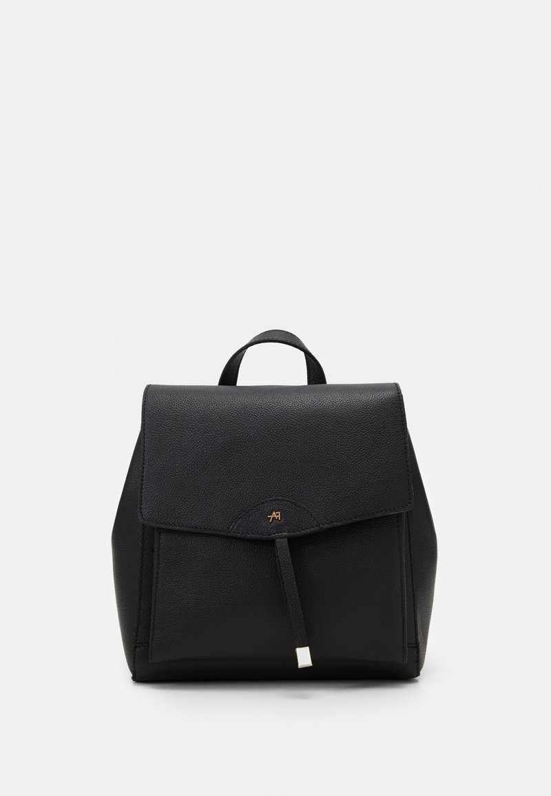 Sac à dos en cuir noir avec fermeture à rabat, poignée supérieure et détail de logo métallique subtil au centre avant.