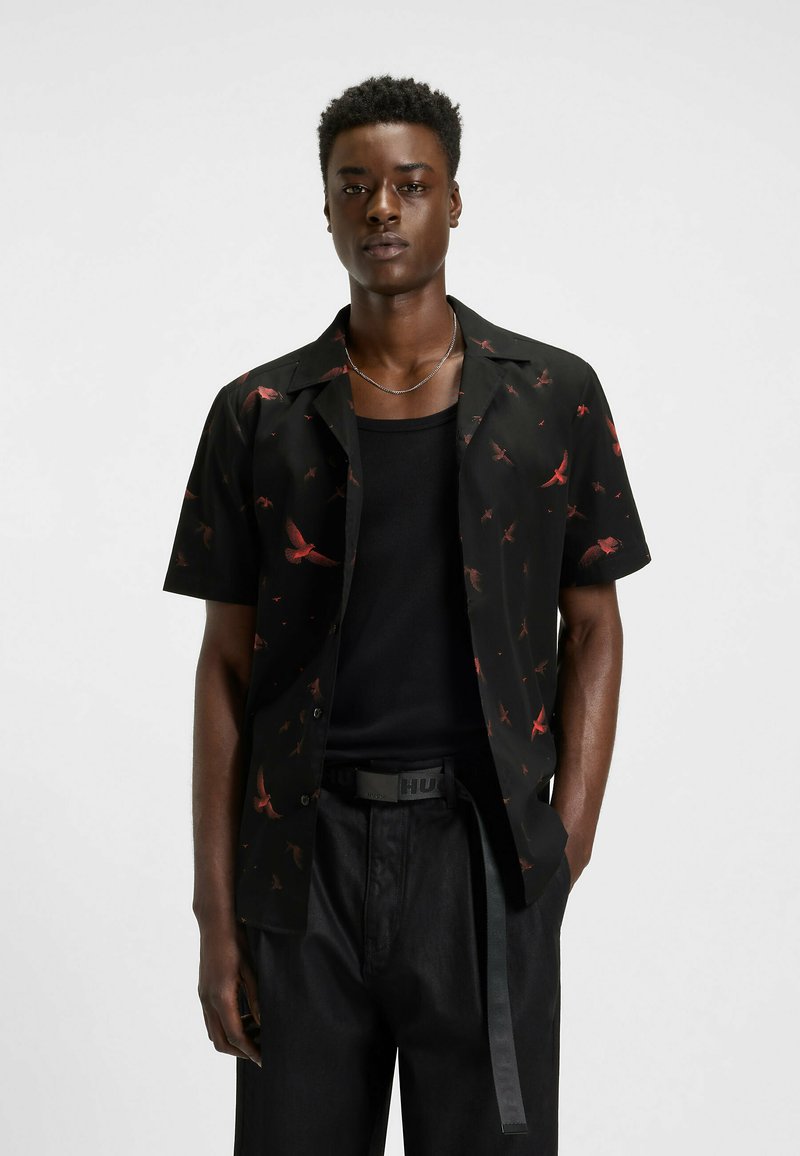 Zwarte korte mouwen overhemd met knopen met een patroon van rode vogels, gemaakt van een gladde stof. Gepaard met een zwart tanktop en broek.
