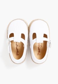 White cotton shoes with cutouts, a buckle strap, and natural fiber soles. Interior features brown leather accents.