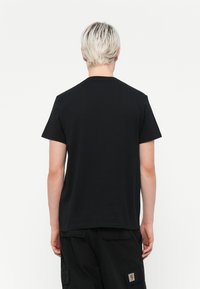 Černé tričko s krátkým rukávem a kulatým výstřihem, s hladkým povrchem. Zadní strana je bez zdobení, což udržuje jednoduchý design.