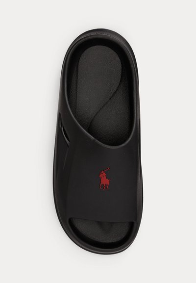 Μαύρο σανδάλι με υφή στο πέλμα και κόκκινο λογότυπο Polo Ralph Lauren στο λουράκι, φωτογραφημένο από πάνω.