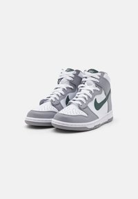Høye sneakers i grå og hvit lær, med grønn Nike swoosh. Har perforert tå, hvite lisser og teksturert gummi såle.
