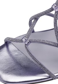 Sandalo con cinturini e una finitura metallica lucida in lavanda, decorato con scintillanti accenti di strass. Design open toe e suola liscia.