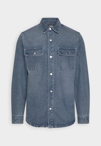 Jeanshemd in Hellblau mit langen Ärmeln, spitzem Kragen und zwei Brusttaschen. Verfügt über silberne Druckknöpfe und einen geraden Saum.
