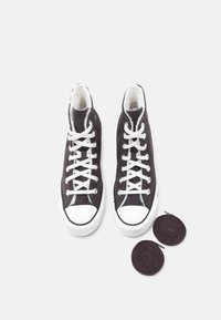 Hoge sneakers van donkergrijze canvas met witte rubberen zolen en neuskapjes, voorzien van witte veters en twee extra ronde veters in donkerpaars.