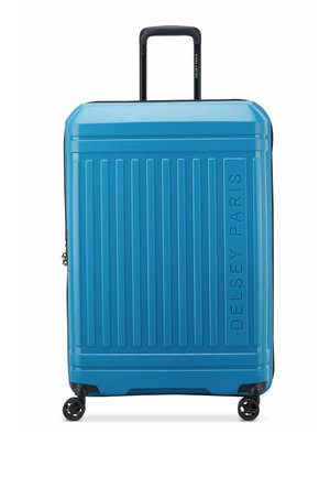 Valigia rigida di un brillante blu, con scanalature verticali, un logo, quattro ruote e un manico telescopico per una facile manovrabilità.