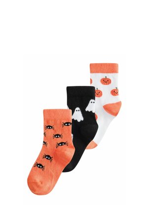 Three children's socks with Halloween designs: orange with black spiders, black with white ghosts, and white with smiling orange pumpkins.