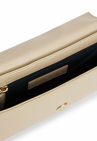 Beige synthetisches Leder Clutch mit glatter Oberfläche, magnetischen und Reißverschluss-Verschlüssen sowie einem dunklen Stofffutter mit einem Markenetikett.