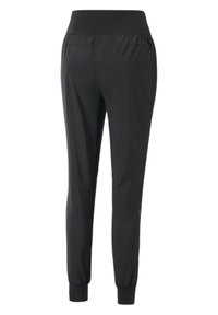 Svarta träningsbyxor med hög elastisk midja, avsmalnande ben och elastiska muddar. Slät, lättviktig tyg med eleganta design detaljer.