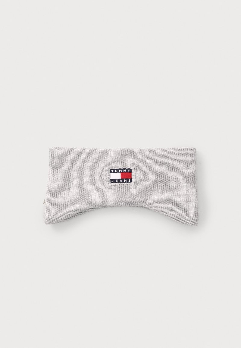 Hallide hallux, mis on valmistatud pehmest kangast, millel on punane, valge ja sinine "TOMMY JEANS" märk. Mugavuse tagamiseks on sellel kaarjas kuju.