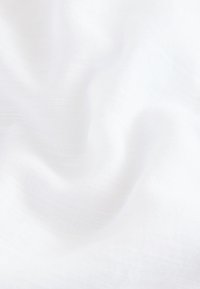 Fehér, texturált szövet, amely puha, enyhén áttetsző hatású. Finoman szőtt mintázata finom mélységet és összetettséget kölcsönöz.