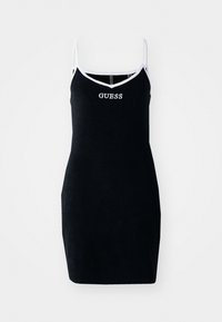 Vestido negro ajustado con tirantes finos. Ribetes blancos en contraste alrededor del escote y las sisas. Logo "GUESS" destacado en blanco en la parte frontal.