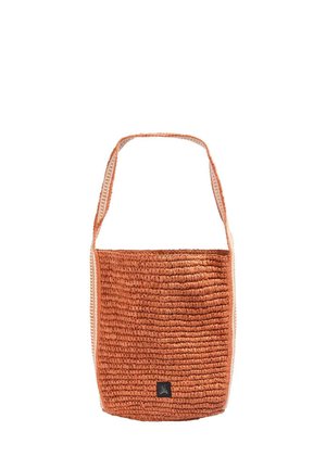 Bolso de hombro tejido color óxido con correa ancha y pequeña etiqueta negra con un icono de calavera blanca en el centro inferior.