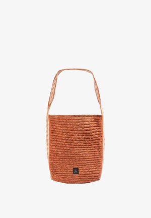 Bolso de hombro tejido color óxido con correa ancha y pequeña etiqueta negra con un icono de calavera blanca en el centro inferior.