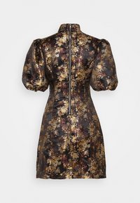 Robe à col haut, manches courtes bouffantes et silhouette ajustée. Présente un motif floral métallique sur fond noir avec une fermeture éclair au dos.