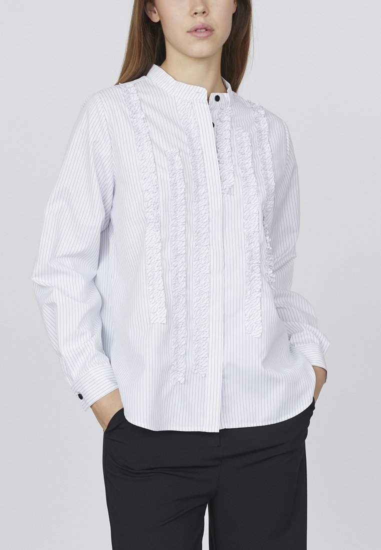 Hvid, stribet bluse med flæsefrontdetalje, knaplukning, båndkrave og lange ærmer. Stof ser glat og let ud.