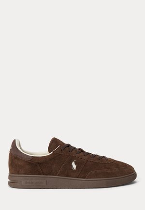 Baskets basses en daim marron avec fermeture à lacets, doublure blanche, logo Polo Ralph Lauren blanc sur le côté et semelle en caoutchouc.