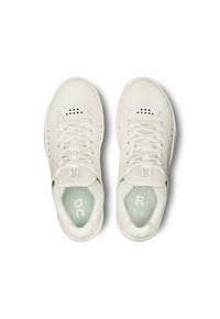 Sneakers bianche con tomaia in pelle, punta rotonda, dettagli perforati e lacci in tessuto. Presentano insoles turchesi con accenti di branding.