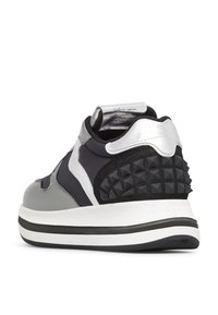 Sneaker nero e argento con un tallone nero texturizzato con borchie a piramide, pannelli laterali lisci grigi e una suola bianca spessa.