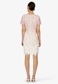 Spitzenkleid mit einem Farbverlauf von Hellrosa zu Weiß, kurzen Ärmeln, Blumendesign, gewelltem Saum und taillierter Silhouette.