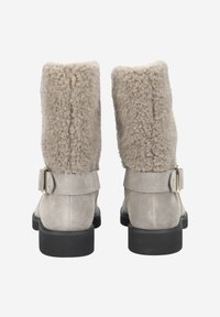 Bottines en daim gris avec un revers en peau lainée texturée et duveteuse, dotées d'une boucle latérale et d'une semelle en caoutchouc noire.