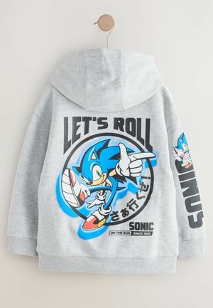 Pilkas gobtuvas, pristatytas neutraliame fone, su dideliu grafikos atvaizdu Sonic the Hedgehog ir tekstu "LEISKIMIS" ryškiomis raidėmis.