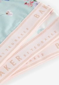 Blomstret tørklæde med en blød mintgrøn baggrund, pink og lilla blomstermønstre samt et lys pink satinfelt med præget branding.