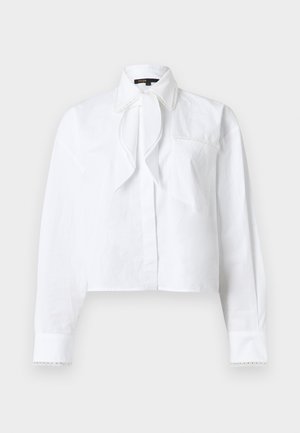 Blouse blanche à manches longues avec col pointu, détail de nœud à l'avant, poche poitrine et bordure en dentelle sur le col et les poignets.