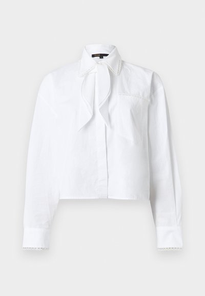 Blouse blanche à manches longues avec col pointu, détail de nœud à l'avant, poche poitrine et bordure en dentelle sur le col et les poignets.