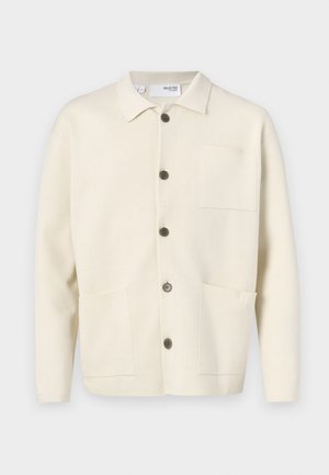 Light beige cardigan with a collared neckline, featuring five brown buttons, two front pockets, and a single chest pocket. Textured fabric.