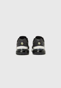 Mustad atleetikaspordijalatsid võrgust ülaosaga, kummist tallaga ja nähtava õhupehmendusega. Omavad valget vahetallat ja kollast logo detaili kandjal.