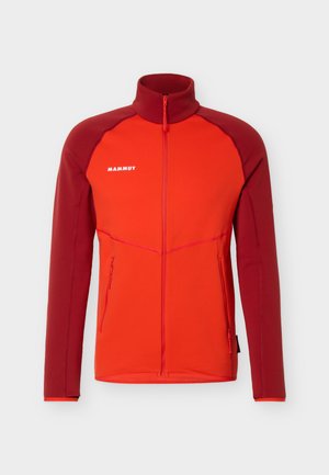 Ανδρικό κόκκινο μπουφάν softshell με μπουρντό μανίκια, πλήρες φερμουάρ μπροστά, δύο τσέπες με φερμουάρ και λογότυπο Mammut στο στήθος.