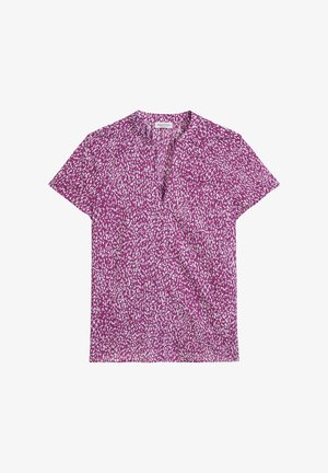 Koszulka z krótkim rękawem w intensywnym fioletowym kolorze z rozproszonym wzorem białych kropek. Posiada dekolt w kształcie litery V oraz lekką teksturę materiału.