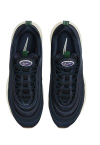 Navy sneakers with a textured synthetic upper, round toe, circular accent logo, and green pull tab; features a prominent white sole.