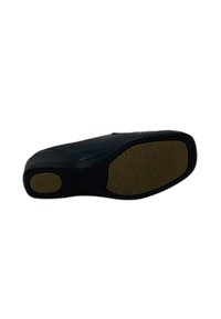 Suola di scarpa nera in pelle con gommini testurizzati marroni nella zona del tallone e della pianta, mostrata su uno sfondo bianco.