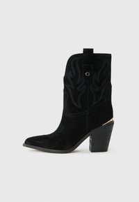 Bottines en suédine noire avec bouts pointus, portant des coutures décoratives, un logo doré et un talon en bloc en bois.
