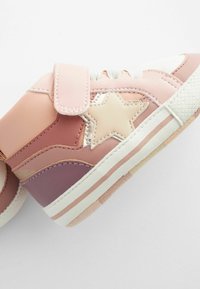 Chaussure de sport pour enfant rose et violette avec un patch étoile beige, des lacets blancs, une sangle Velcro, et une semelle blanche avec des rayures roses.
